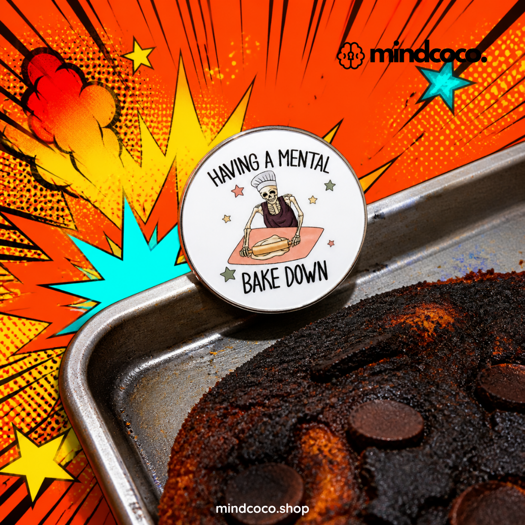 "Mental Bake Down" enamel pin – lifestyle flat lay, neurodivergent and mental health humour