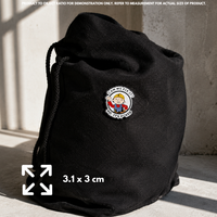 Person holding "Chaos Certified" enamel pin showing 3×3cm size