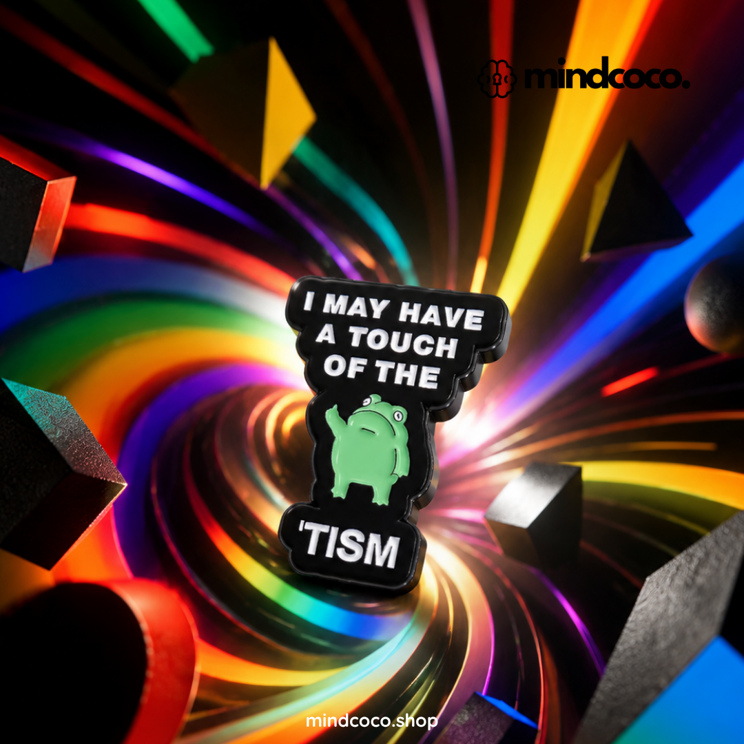 "A touch of the tism" enamel pin – lifestyle flat lay, neurodivergent and mental health humour