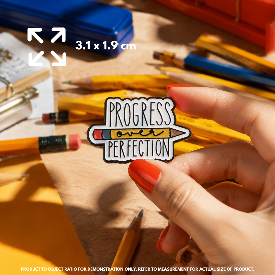 Person holding "Progress Over Perfection" enamel pin showing 3×3cm size