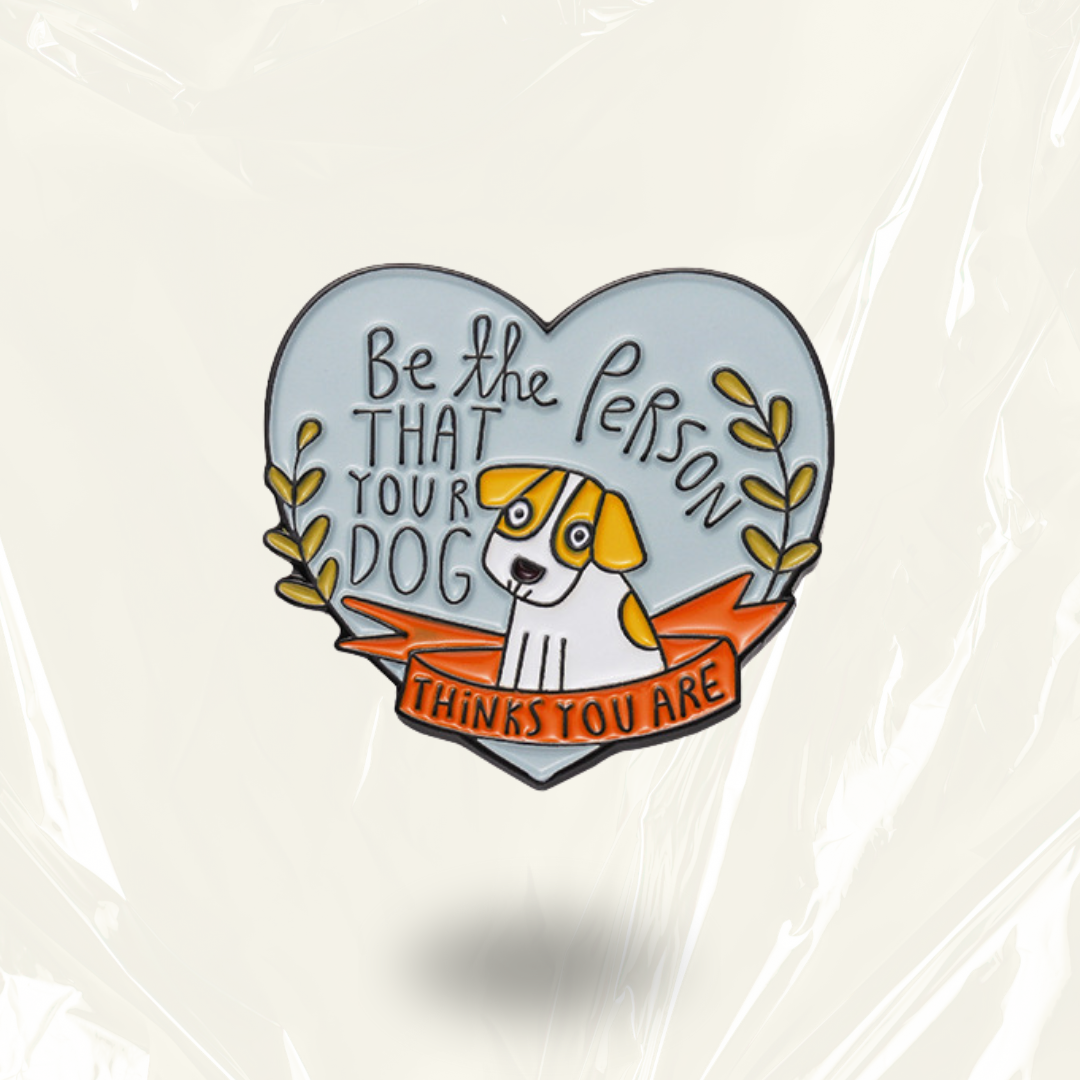 MindCoco "Be the Person Your Dog Thinks You Are" Pin: A wholesome heart-shaped enamel badge featuring a hand-drawn dog illustration on a light blue background. This sentimental accessory serves as a neurodivergent-friendly tool for self-compassion and mental health validation, celebrating unconditional love.