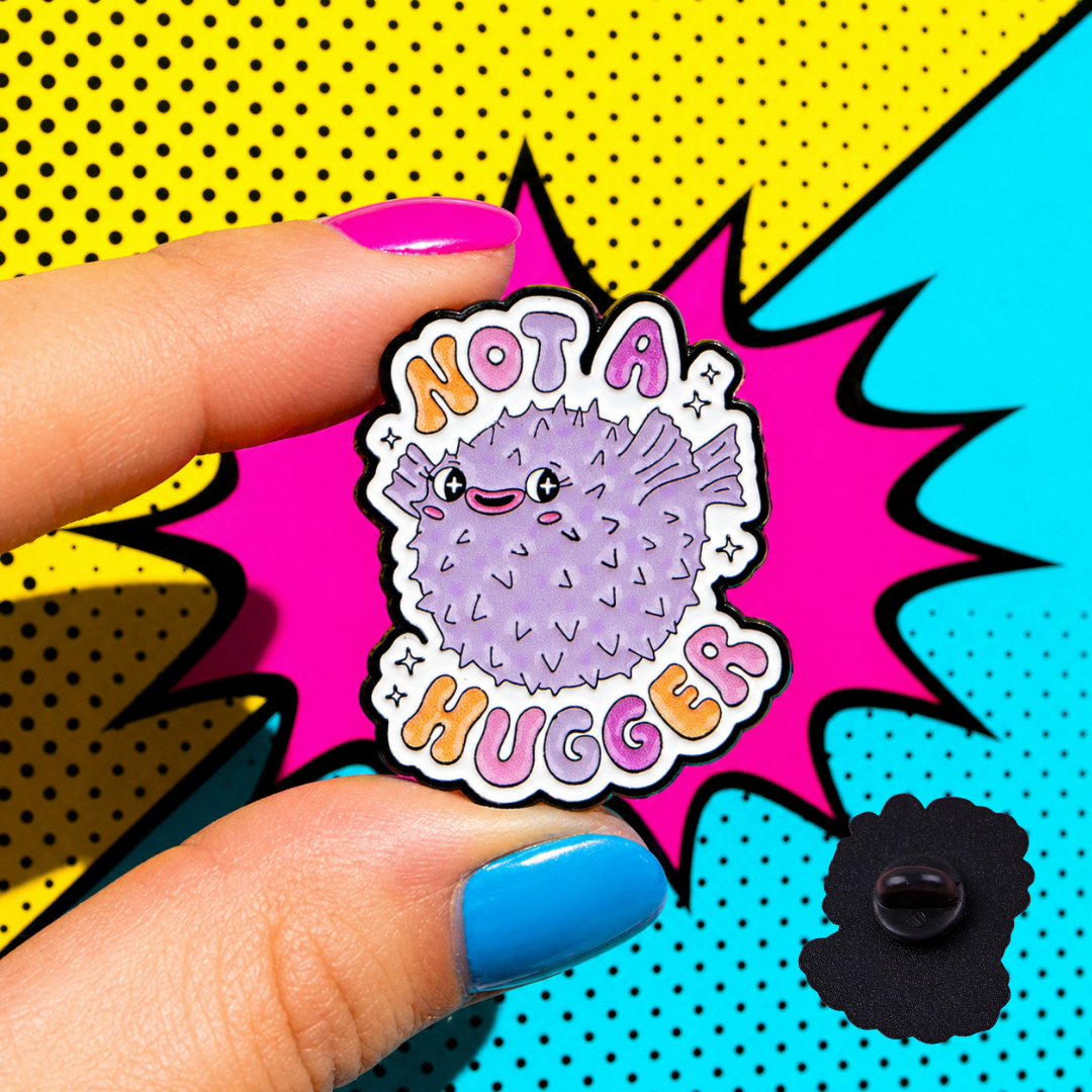"Not A Hugger" enamel pin worn on jacket – neurodivergent and mental health humour