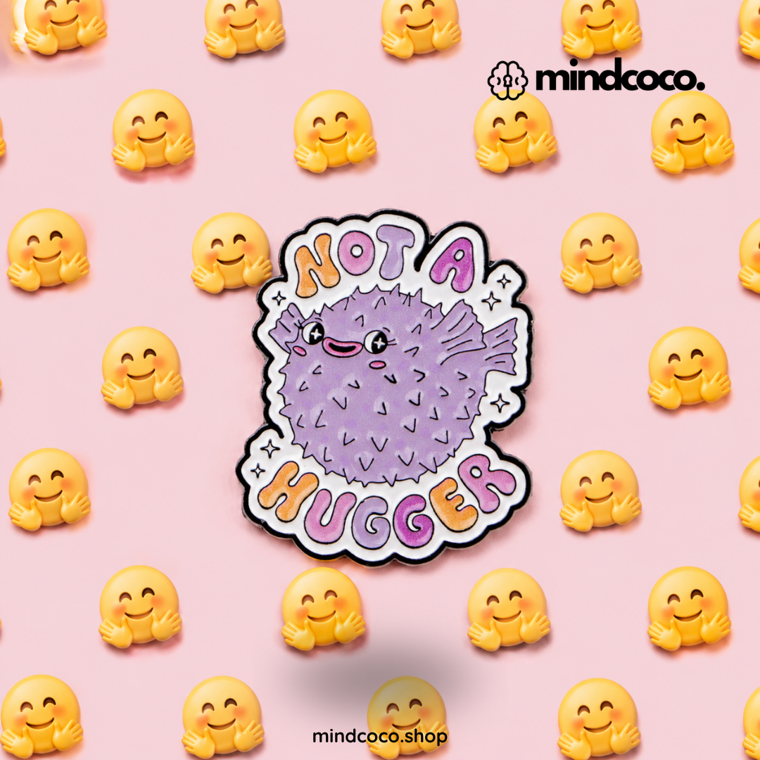 "Not A Hugger" enamel pin – lifestyle flat lay, neurodivergent and mental health humour