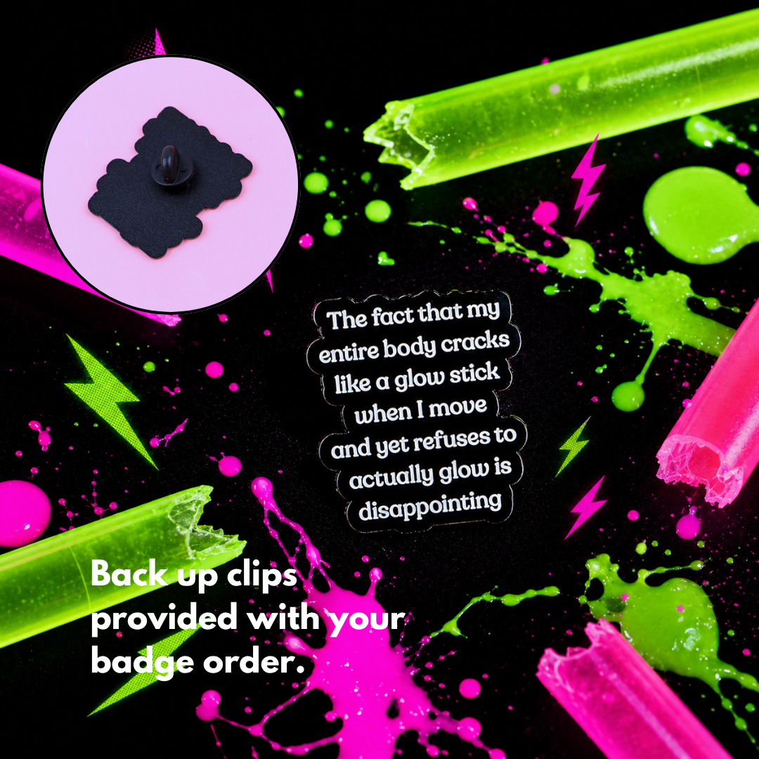 "Glowstick" enamel pin worn on jacket – neurodivergent and mental health humour