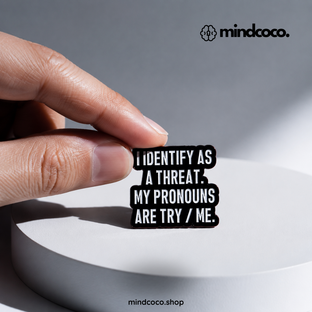 "Pronouns: Try Me" enamel pin – lifestyle flat lay, neurodivergent and mental health humour