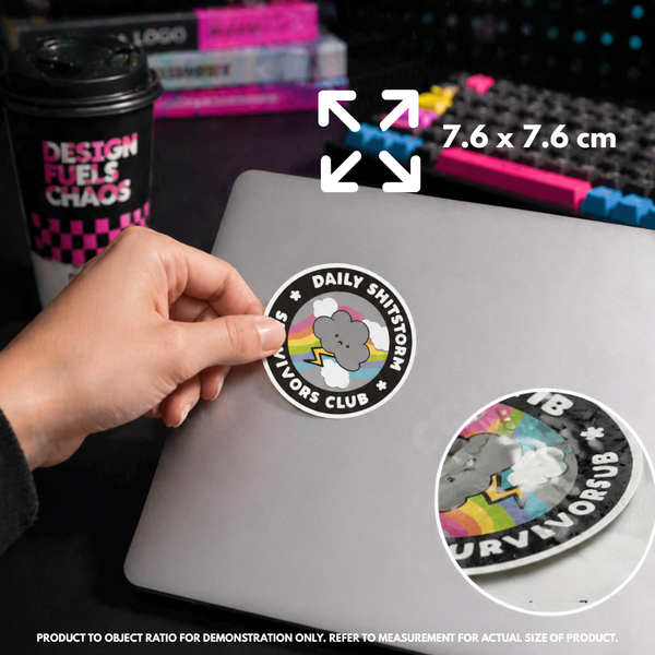 Person holding "Daily Shitstorm Survivors Club" vinyl sticker showing 7.6×7.6cm size