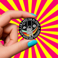 "Fan of Space" enamel pin – lifestyle flat lay, neurodivergent and mental health humour